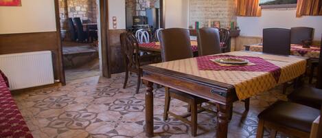 Un comedor con una larga mesa de madera, varias sillas y un suelo con diseño.
