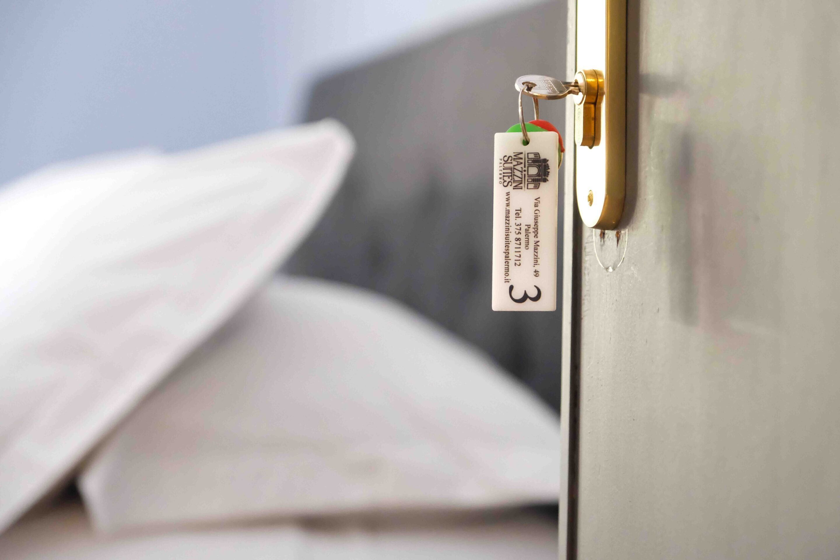 Un primo piano di una porta di camera d'albergo con una tessera magnetica e un cartellino.