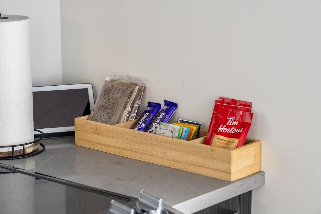 Ein Holztablett mit verschiedenen Kaffeeprodukten auf einer Arbeitsfläche.