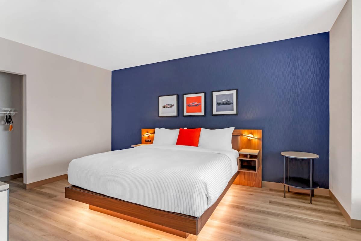 Ein modernes Schlafzimmer mit einem Bett, Nachttischen und Wandbildern.