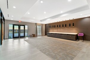 Un vestíbulo espacioso con un mostrador de recepción grande, un banco y vistas a través de puertas de vidrio.