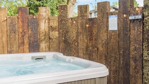 A hot tub in a wooden enclosure with a wooden fence and a sign indicating it is a hot tub. - 1 bedroom accommodation in Faringdon (Faringdon)