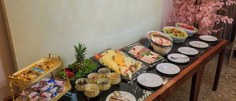 Una mesa de buffet en el Executive Lounge del Nile Suites Plaza, con diversos alimentos y condimentos.