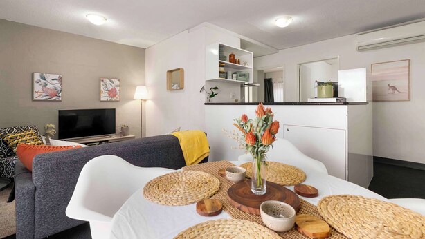 Una sala de estar moderna con sofá, televisión y elementos decorativos.