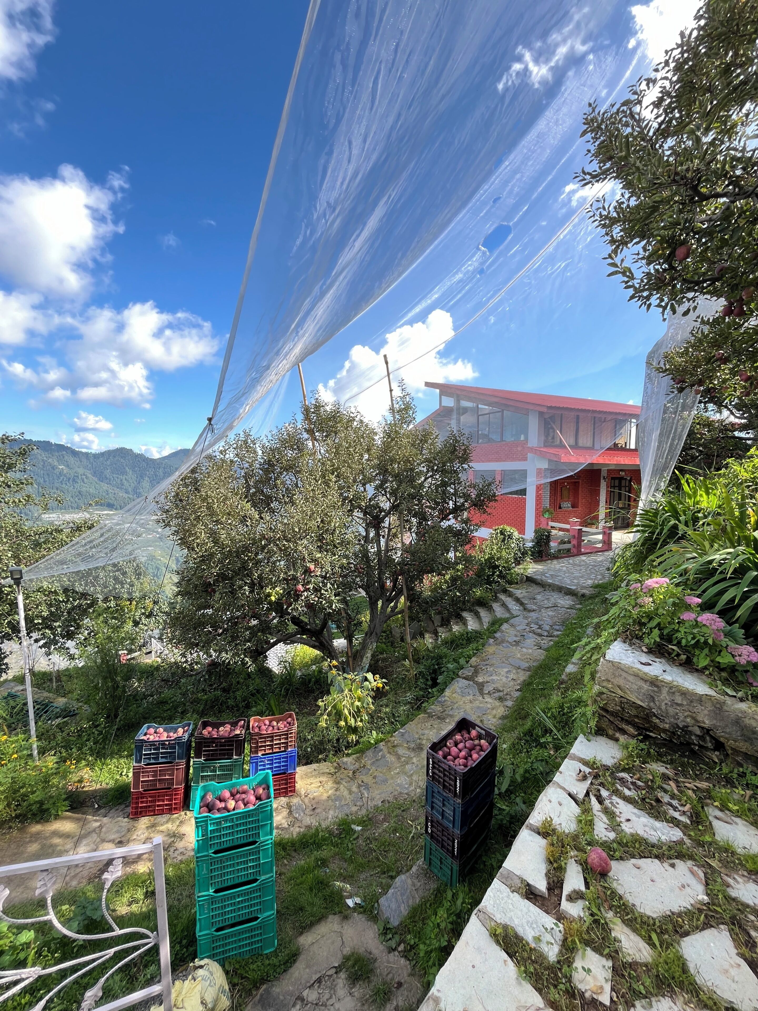 Paisaje montañoso con un edificio de techo rojo y ventanas de vidrio.