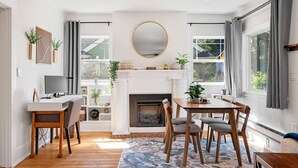 Una sala moderna con chimenea, comedor y televisor.