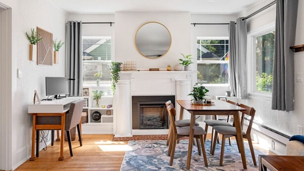 Un salon moderne avec une cheminée, un coin repas et un téléviseur.