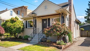 Une maison de plain-pied avec un porche à l’avant, une cheminée et une boîte aux lettres.