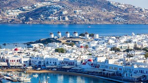 A coastal town with white buildings, a harbor with boats, and windmills on a hill. - My Rental Homes - Viila Rose 2  only 1 km from Agios Stefanos beach. Shared pool (Mykonos)