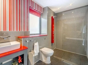 Un baño moderno con ducha, inodoro y lavamanos.