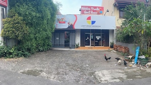 A building with a sign for 'Ndalem Pundhi Guest House' and 'Light Group Indonesia'.