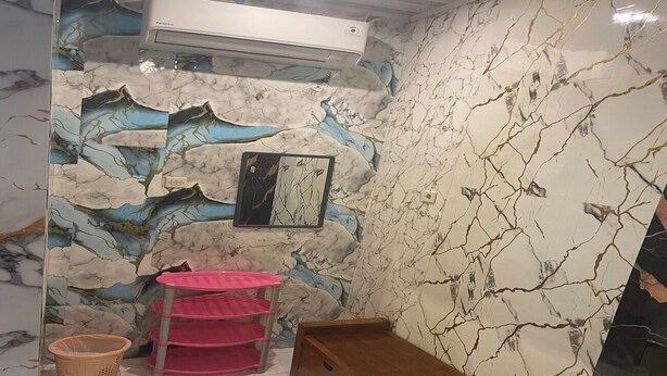 A bathroom with a marble wall, a pink shelf, a wooden bench, and a basket.