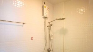Ein kleines, kompaktes Badezimmer mit Toilette, Dusche und Wandheizung.