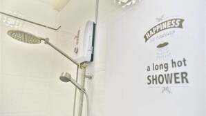 Ein Badezimmer mit Dusche, Handtuchhalter und einem Schild mit der Aufschrift 'Glück ist eine lange, heiße Dusche'.