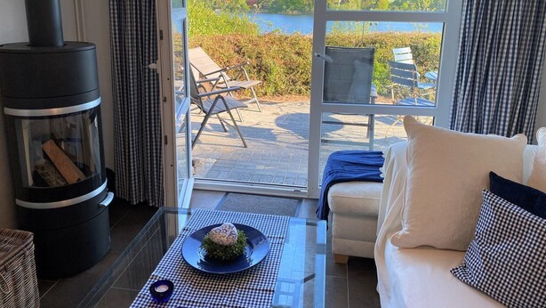 A cozy room with a fireplace, a sofa, and a view of a lake.