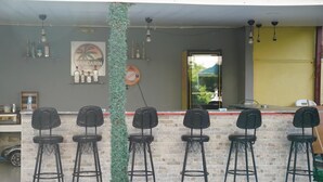 A bar area with a brick counter, black bar stools, hanging lights, and a 'MANDARIN' sign. - Mandarin Beach Hotel ve Restaurant  (Menderes)