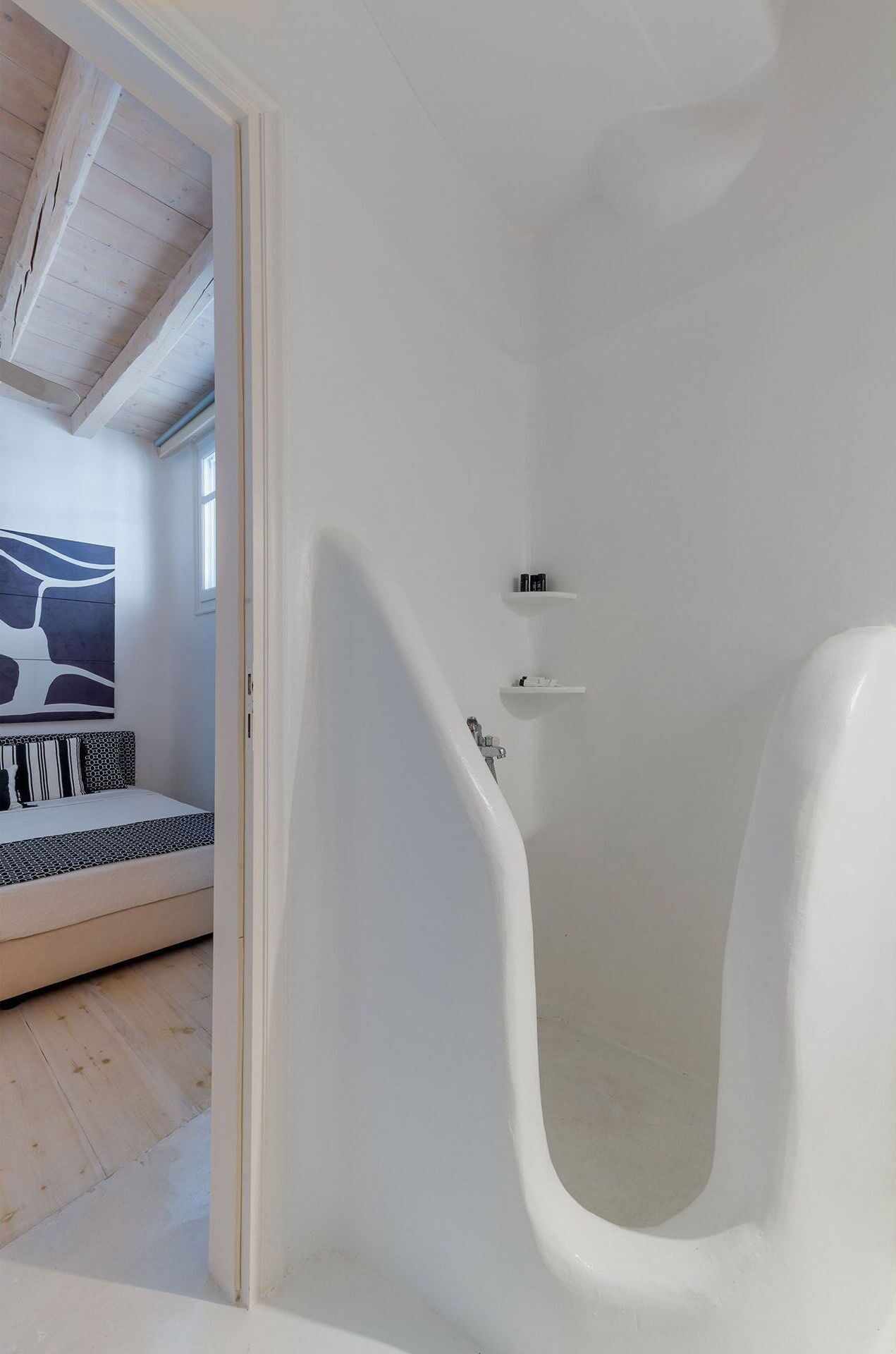 Um banheiro moderno com uma banheira de apoio, área de chuveiro e uma cama com design exclusivo de cabeceira.