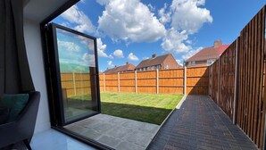 A modern patio with a glass door leading to a backyard. - Perfect Contractor house/3 free parking space/EV charging/Secure/Quiet/Modern (Waltham Cross)