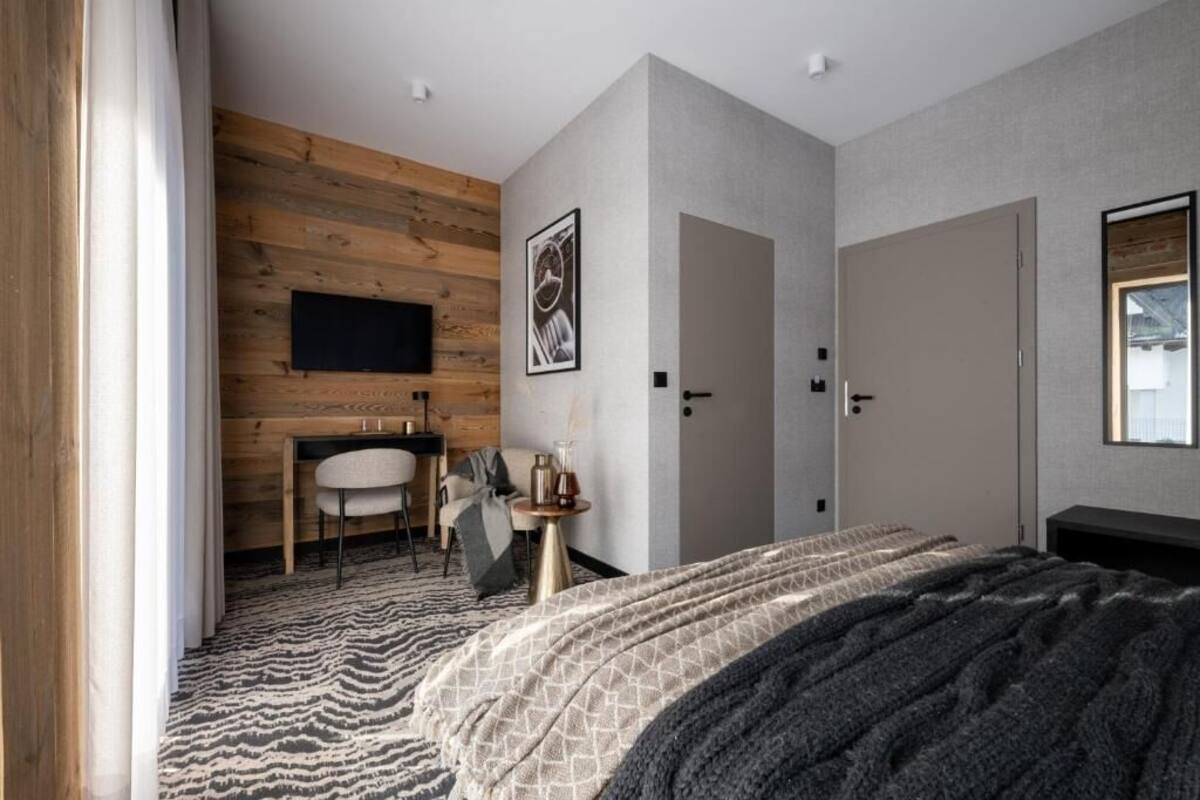 Ein modernes Schlafzimmer mit Bett, Schreibtisch und Stuhl.