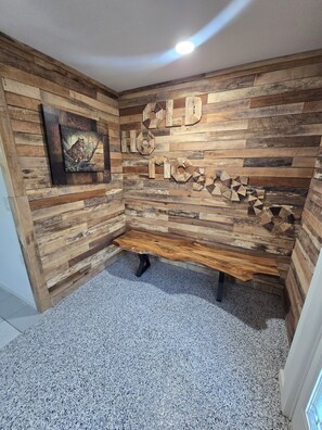 Ein Zimmer mit einer Wandgestaltung aus Holz, einem gerahmten Bild und einer Bank.