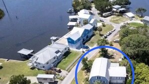 An aerial view of a residential area with houses, a dock, and a body of water. - Spacious 5-bedroom beautiful water view home with private boat dock! (Homosassa)