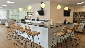 A modern kitchen with a central island, bar stools, pendant lighting, and a dining area with a sofa and chairs. - 4 bedroom townhouse in La Cala (Mijas Costa)