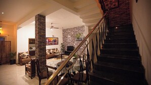 A spacious living area with a staircase, a fireplace, and a television.