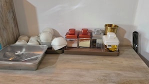 A kitchen counter with various utensils, bowls, and containers. - Kandy Comforts (Katugastota)