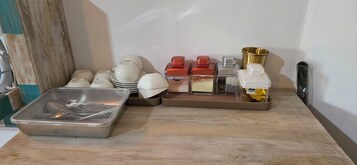 Una encimera de cocina con varios utensilios, cuencos y recipientes.