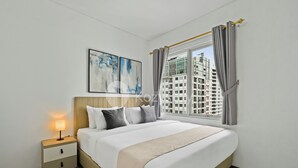 A modern hotel room with a large bed, a bedside table with a lamp, and a window with curtains. - Minoa by Kozystay - Thamrin (Jakarta)