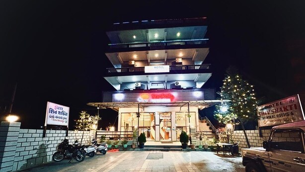 Un hotel con letrero, escaleras y un árbol de Navidad.