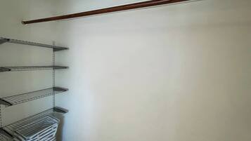 Un armario con estantes metálicos y una viga de madera.