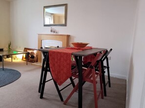 A dining area with a table, chairs, a mirror, and a fireplace. - Tranquil Retreat in Ely City Center (Ely)