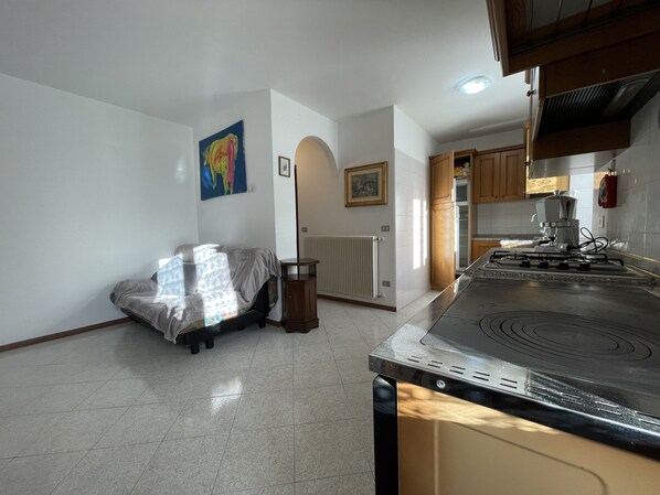 A kitchen with a stove, cabinets, and a radiator.