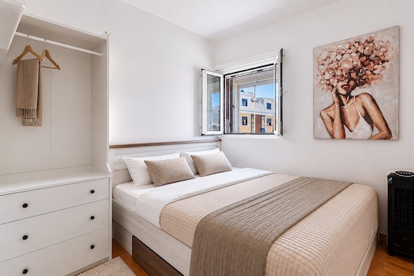 A bedroom with a bed, a wardrobe, a window, and a painting.
