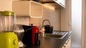 Eine Küche mit Arbeitsplatte, Mixer, Wasserkocher und Spüle.