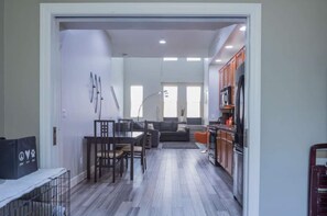 A modern kitchen with wooden cabinets, a refrigerator, and a dining area with a table and chairs. - Downtown Tempe Escape, Comm. Pool, Walk to ASU (Tempe)