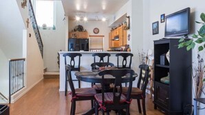 A compact living space with a dining area, kitchen, and entertainment unit. - North Phoenix Condo – Sunset Views + Community Heated Pool (Phoenix)