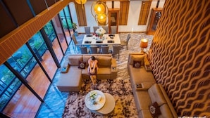 A spacious room with a large dining table, multiple sofas, and a patterned carpet.