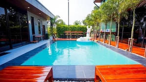 A swimming pool with wooden deck seating and a small inflatable float.