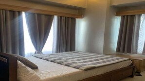 Un dormitorio moderno con una cama grande, cabecera de madera y cortinas.
