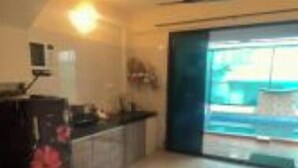 Een ruime keuken met een groot eiland, een eethoek met een tafel, en een schuifdeur naar een balkon.