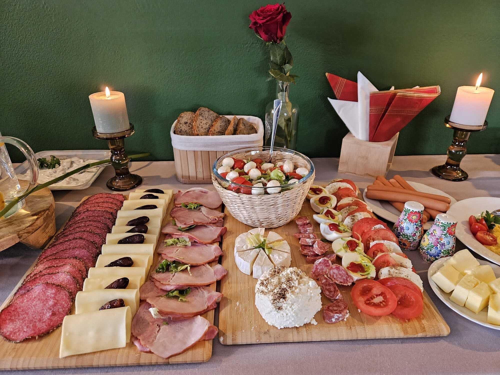 Diverse etenswaren, zoals vlees, kaas en een salade, gepresenteerd op een houten plank.