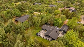 Vue aérienne d’un quartier résidentiel composé de nombreuses maisons, entourées d’une végétation luxuriante.