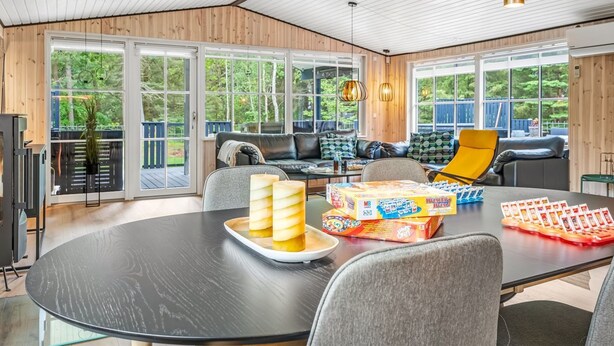 Un salon moderne doté d’une grande table ronde, de sièges confortables et de larges fenêtres offrant une vue sur l’extérieur.