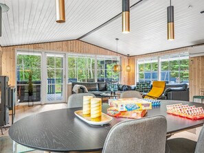 Un salon moderne doté d’une grande table ronde, de sièges confortables et de larges fen êtres offrant une vue sur l’extérieur.