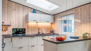 Une cuisine moderne avec un lambris en bois, une lucarne et une grande fenêtre.