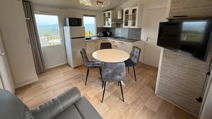 Una cocina compacta con comedor, un televisor de pantalla plana y vistas al exterior.
