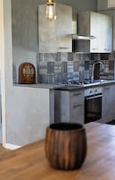 Una cocina de diseño moderno, con estufa a gas, horno y armarios de acero inoxidable.