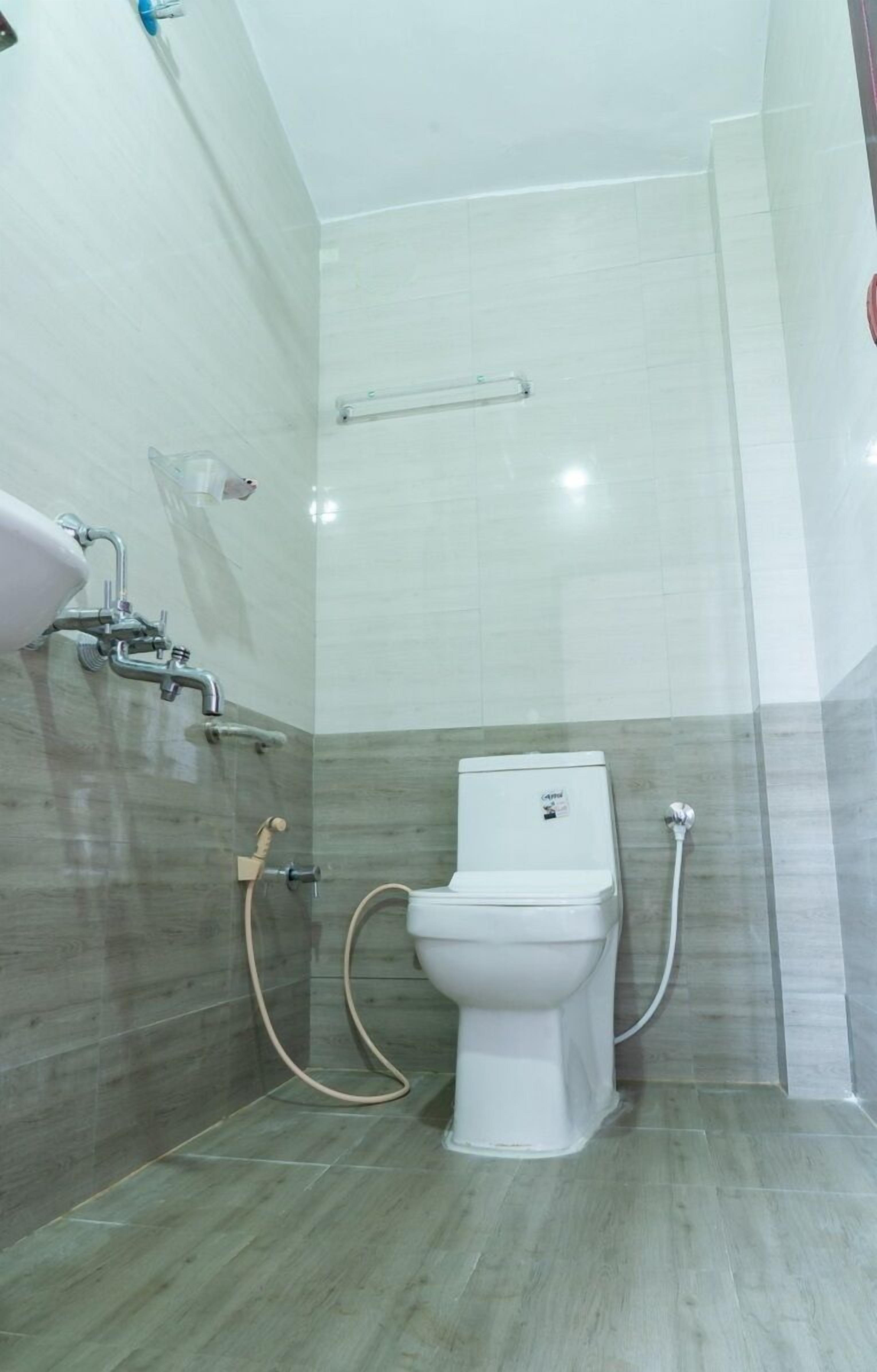 A bathroom with a toilet, a shower, and a bidet.
